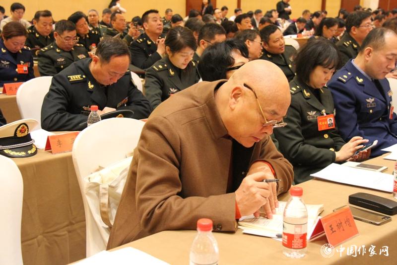 在中國作家協會第九次全國代表大會第三次全體會議上，代表王樹增認真作筆記。