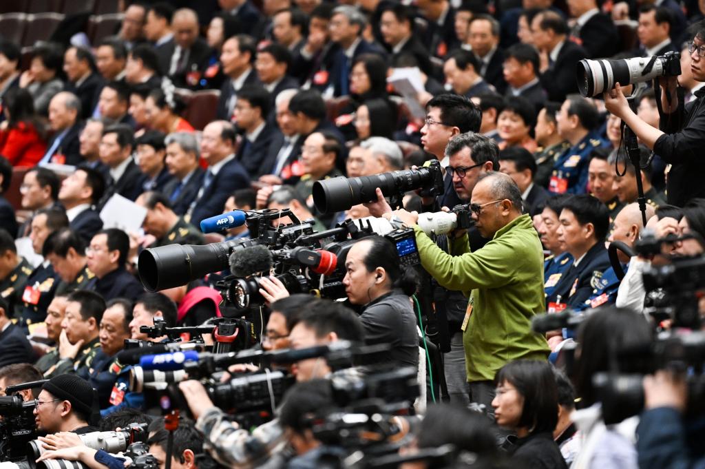 3月8日，十四屆全國人大二次會議在北京人民大會堂舉行第二次全體會議。這是記者在會議現場采訪。新華社記者 牟宇 攝