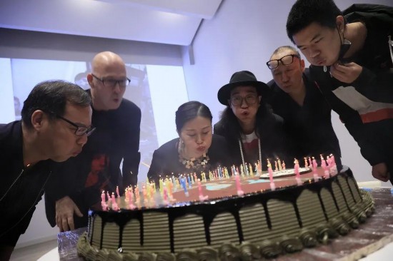 北京，“人人都是藝術家——約瑟夫·博伊斯百年誕辰紀念活動”現場，眾人切生日蛋糕為約瑟夫·博伊斯慶生。蛋糕上插了100根蠟燭