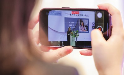 在2024上海國際文學周主論壇的會場，一位觀眾在用手機錄制日本推理小說家湊佳苗的發言。上海國際文學周供圖